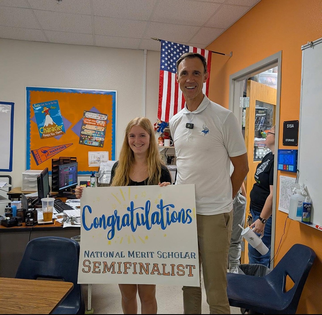 West Orange senior Emily Tatum stood with a poster after she was named a National Merit Scholarship Semifinalist.