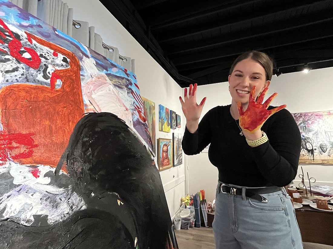 Victoria Pestrichello covered her hand in red paint to make her mark on the collaborative piece that will be unveiled at the Young Creatives Showcase.