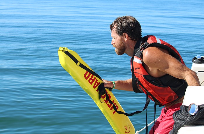 Cliff Talbott, lifeguard two with the Manatee County Beach Patrol Division, demonstrates for Longboat Key Fire Rescue officers how to make a controlled dive into the water while conducting a marine rescue. The beach patrol led a multi-department training on Sept. 24 off Coquina Beach.