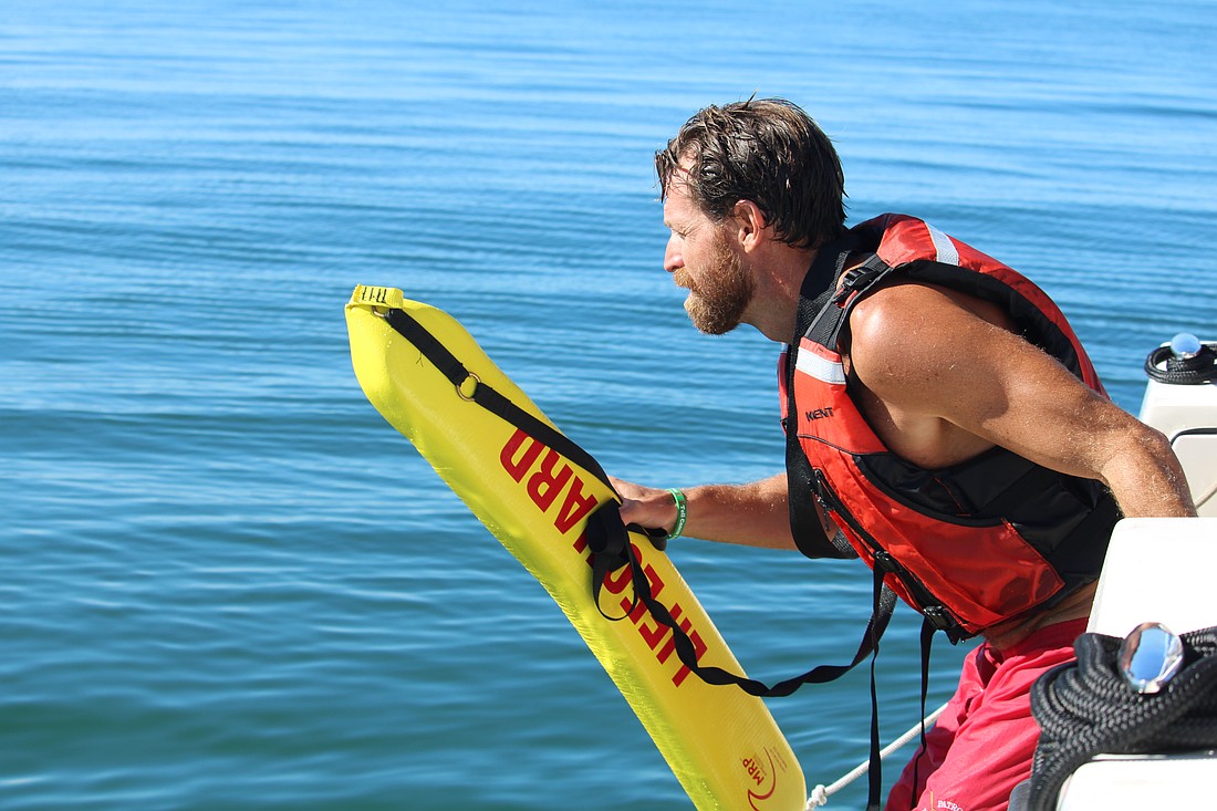 Cliff Talbott, lifeguard two with the Manatee County Beach Patrol Division, demonstrates for Longboat Key Fire Rescue officers how to make a controlled dive into the water while conducting a marine rescue. The beach patrol led a multi-department training on Sept. 24 off Coquina Beach.