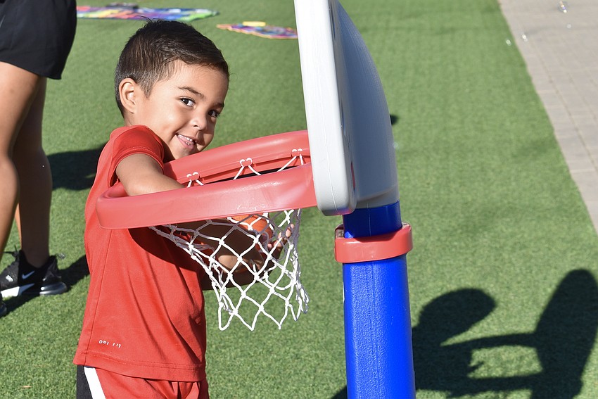 Parrish's Damien Silva, 3, knows what to do, but he'd rather not let go of the basketball.