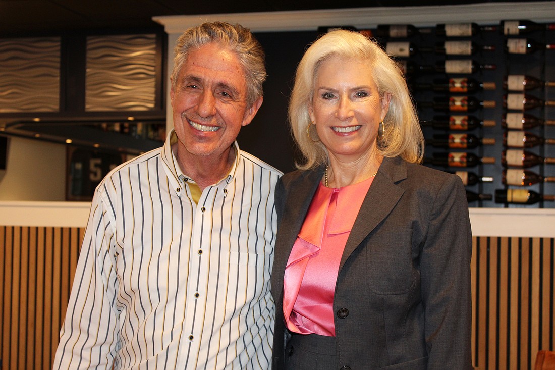 Outgoing Kiwanis Club of Longboat Key president Michael Garey passes the gavel to Danielle Gladding at a Sept. 25 meeting at his restaurant, the Lazy Lobster.
