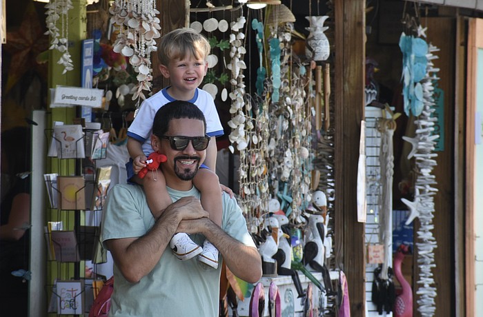 Eddie Molina and his son Theo Molina, 2, take a stop outside a shop in Siesta Key.