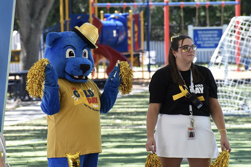The Panther waves pom poms besid teacher Sierra Koske.