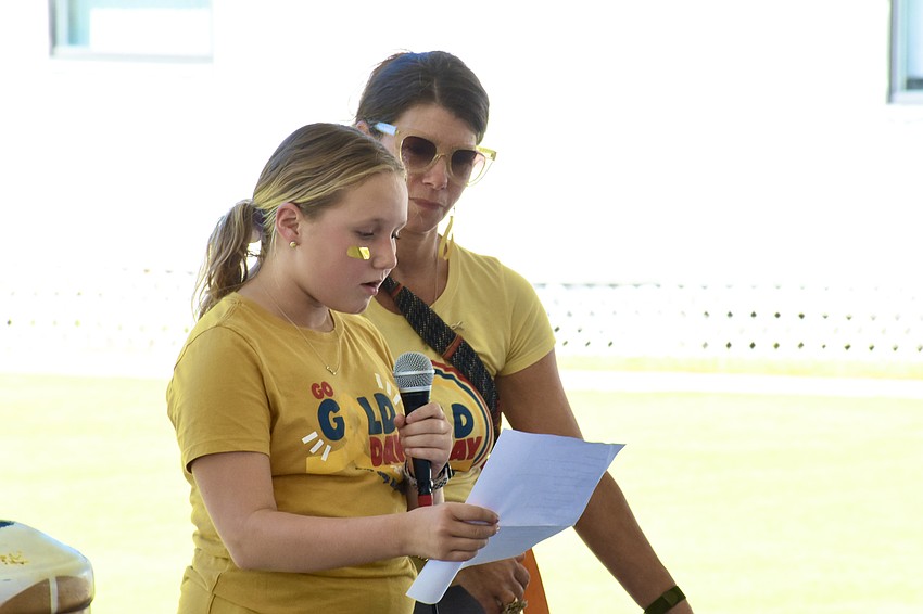 Grace Zaborney, a sixth grader at Booker Middle School, reads out a poem as she stands beside Laura Gilkey.