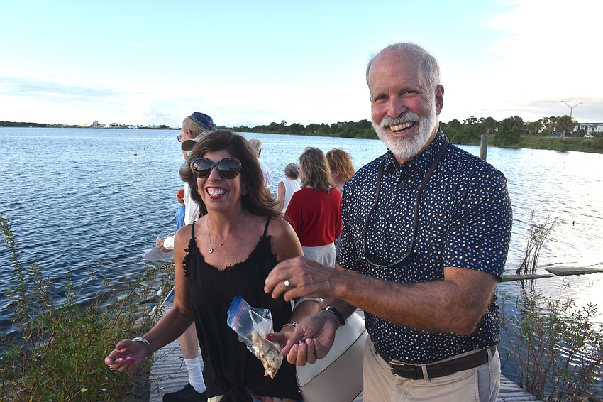 Gwen and David Murphy toss bread into the water to cast their sins at the Temple Emanu-El Tashlich ceremony at Nathan Benderson Park.