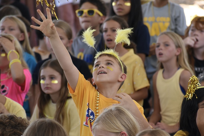 Third grader Dax Gau throws a pom-pom.
