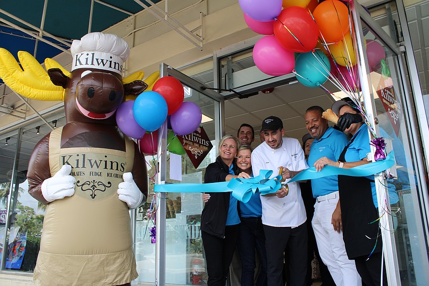 Smiles abound at the Kilwins on St. Armands Circle as assistant manager Dino Coit cuts the ribbon to welcome back customers to enjoy fudge, ice cream and other sweet treats.