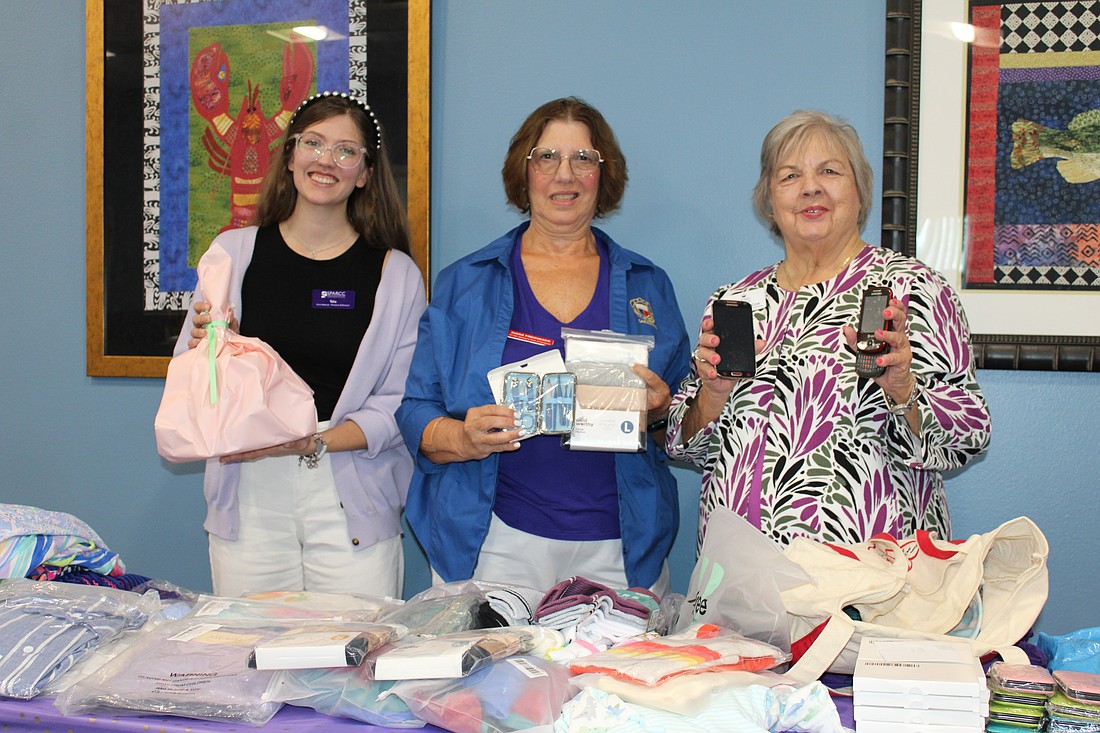 To recognize Domestic Violence Awareness month, GFWC's Woman's Club of Sarasota, including members Diana Freidinger, center, and Sharlene Cox, right, presented victim advocate Talia Casey with $1,400 and donated items to support Safe Place and Rape Crisis Center's mission.