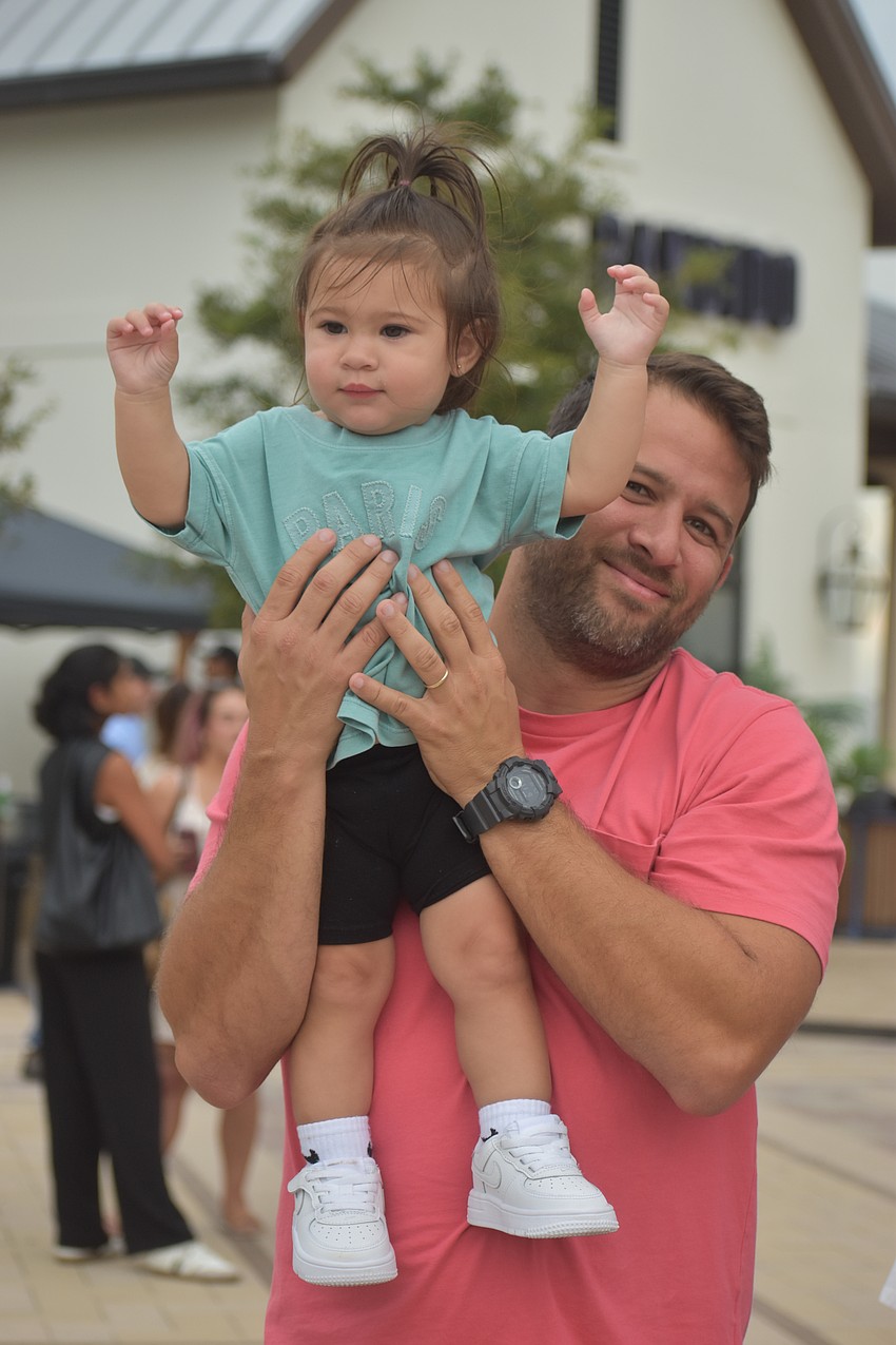 Lakewood Ranch's 1-year-old Alaska Muñoz gets a better view for No Filter when her father Eduardo Muñoz picks her up.