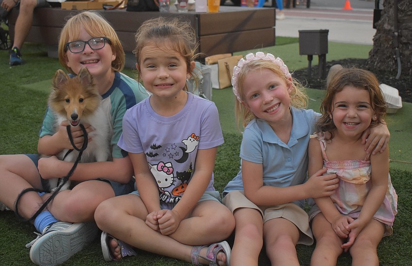 Mark Eubanks, Vika Tyujina, Georgia Eubanks and Nevada Diorides play with Chloe, a shetland sheepdog, that the Eubanks family got six weeks ago.