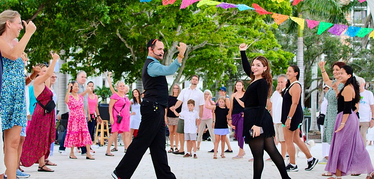 Instructors Juan Uribe and Miranda Vidro from Fred Astaire Dance Studios demonstrate some salsa dance moves at The Bay's third anniversary celebration.