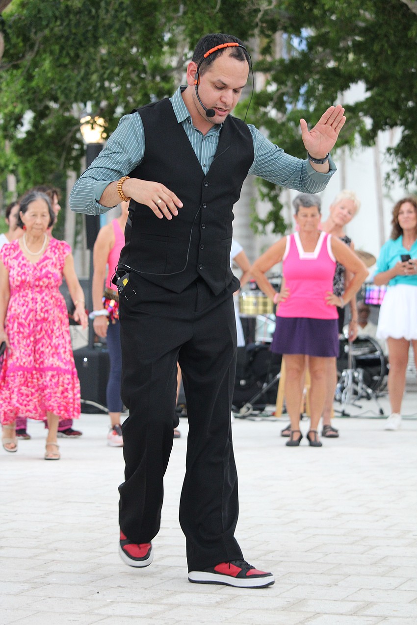 Instructor Juan Uribe of the Fred Astaire Dance Studio demonstrates the steps to a salsa for community members helping celebrate The Bay's third anniversary.