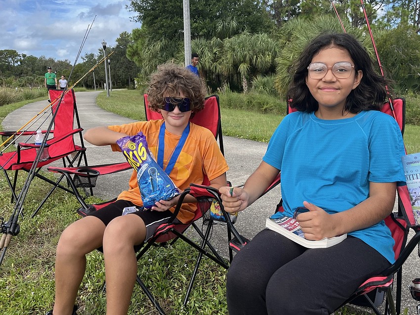 The fish aren't biting for Ellenton's Matthew and Selah Littleton, so they opt for a snack break.