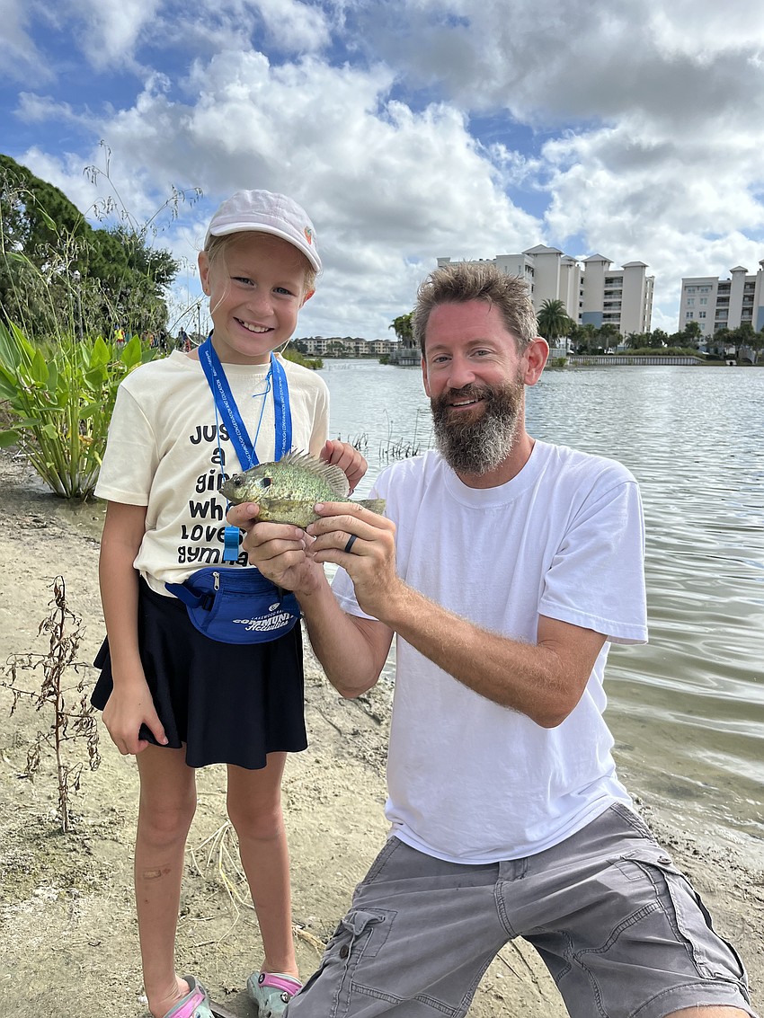Irelynn and Rick Denike pose with the 8-year-old's catch of the day.