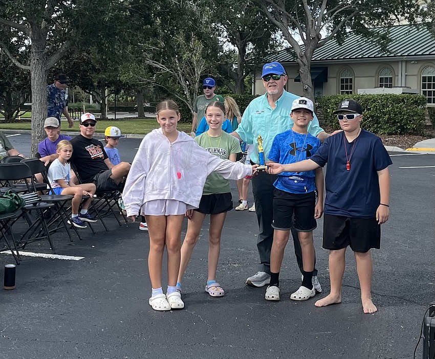 Cora Ortega, Ally Miller, Jeffrey Millea and Wesley Helm share third place in the 10-14 age group. Ed Van Stedum, president of the Lakewood Ranch Anglers Club, poses with the winners.