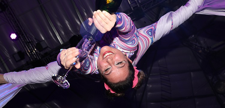 Aerialist and CAC coach Siena Hartzell pours champagne from a unique perspective.