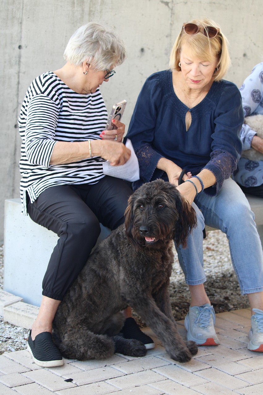 Kay Goodman and Georgia Salaverri take in the Oct. 4 pet blessing service with Eli, a golden retriever and poodle mix, at St. Boniface Episcopal Church.