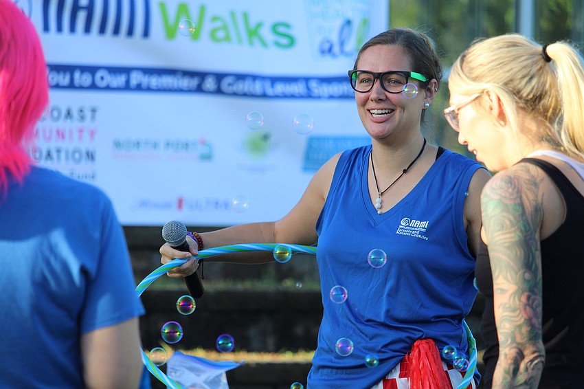 Emcee Beth Walters, training director with NAMI Sarasota and Manatee Counties, raises the energy at the NAMIWalks opening ceremonies with some hula hooping.