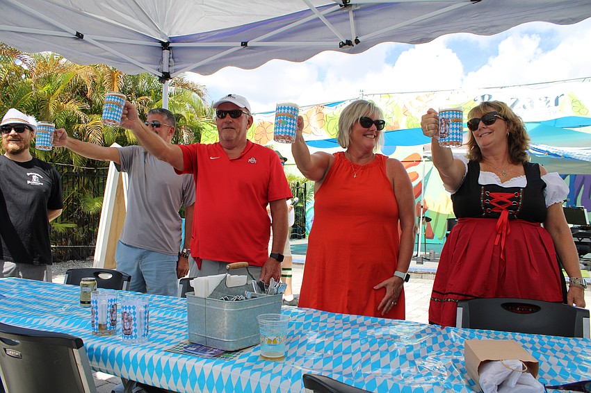 From right, Penny Brewer, Joni Citron and Dean Argabright all give the stein-holding competition a good bid, but it's Anthony Baffo on the left who eventually places first.