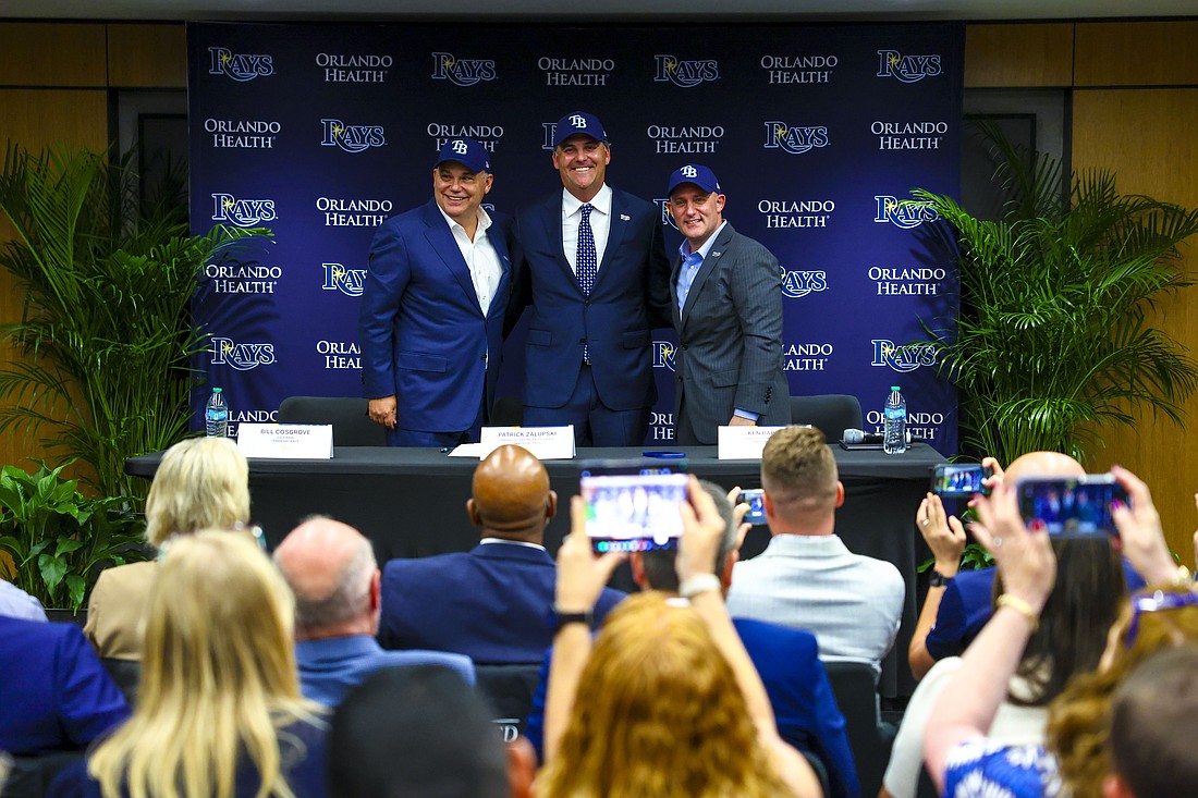 The Tampa Bay Rays new owners dawn caps on Oct. 7. L-to-R Bill Cosgrove, co-chair; Patrick Zalupski, managing partner co-chair; Ken Babby, chief executive officer.