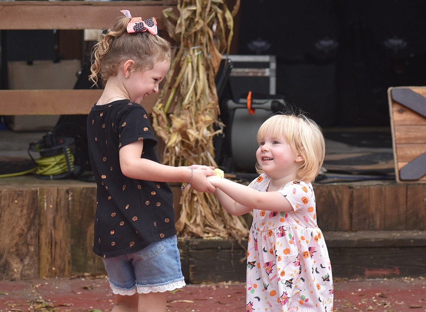 Strangers just moments before, Punta Gorda's Dalphia Morgan, 6 and Parrish's Brynley Brown, 2, share a dance to the tunes of Bob and Tom.