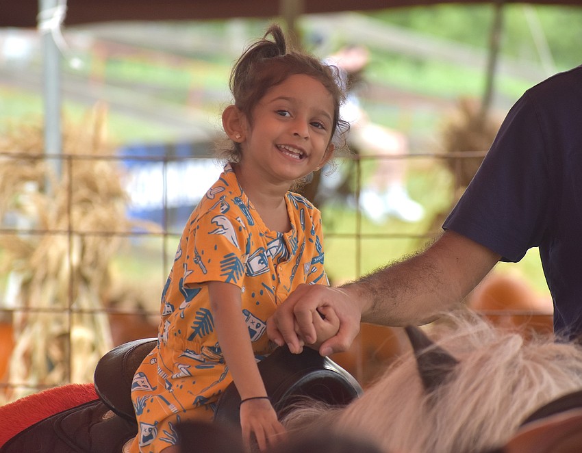 Parrish's Niva Zalavadiya, 3, rides a pony at the Pumpkin Festival at Hunsader Farms on Oct. 11.