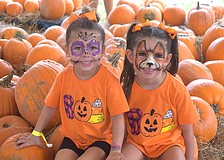 Sarasota's Ariana Swayka, 4 and Alexia Swayka, 6 are in the full holiday spirit with their Halloween themed shirts and face paint.