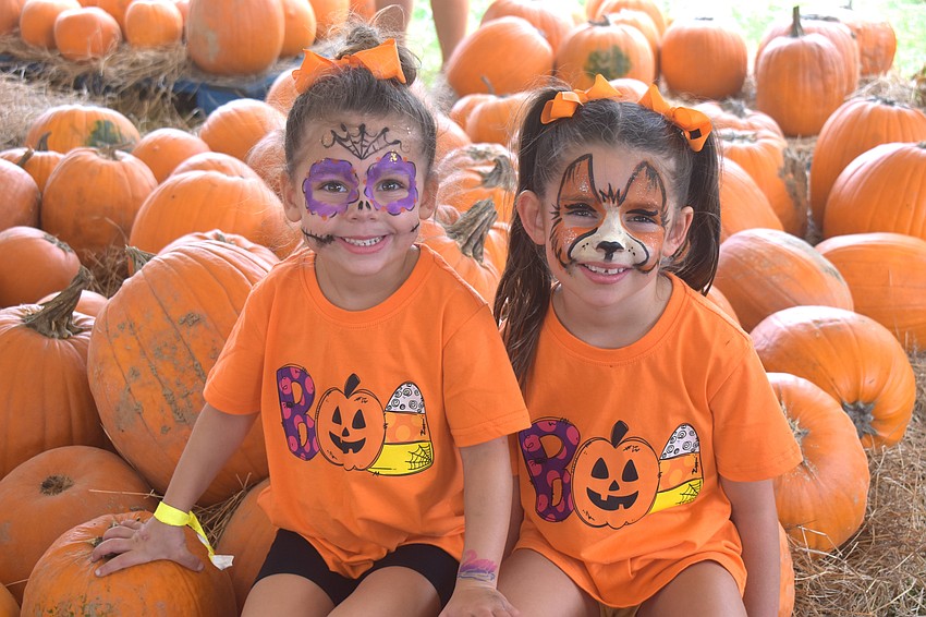 Sarasota's Ariana Swayka, 4 and Alexia Swayka, 6 are in the full holiday spirit with their Halloween themed shirts and face paint.