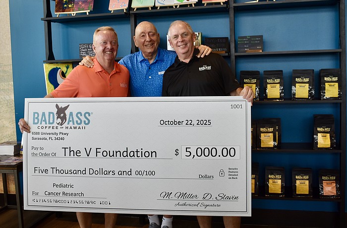 Danny Slavin and Michael Miller, owners of Bad Ass Coffee of Hawaii on University Parkway, donate $5,000 to the Dick Vitale Pediatric Cancer Fund Oct. 10.