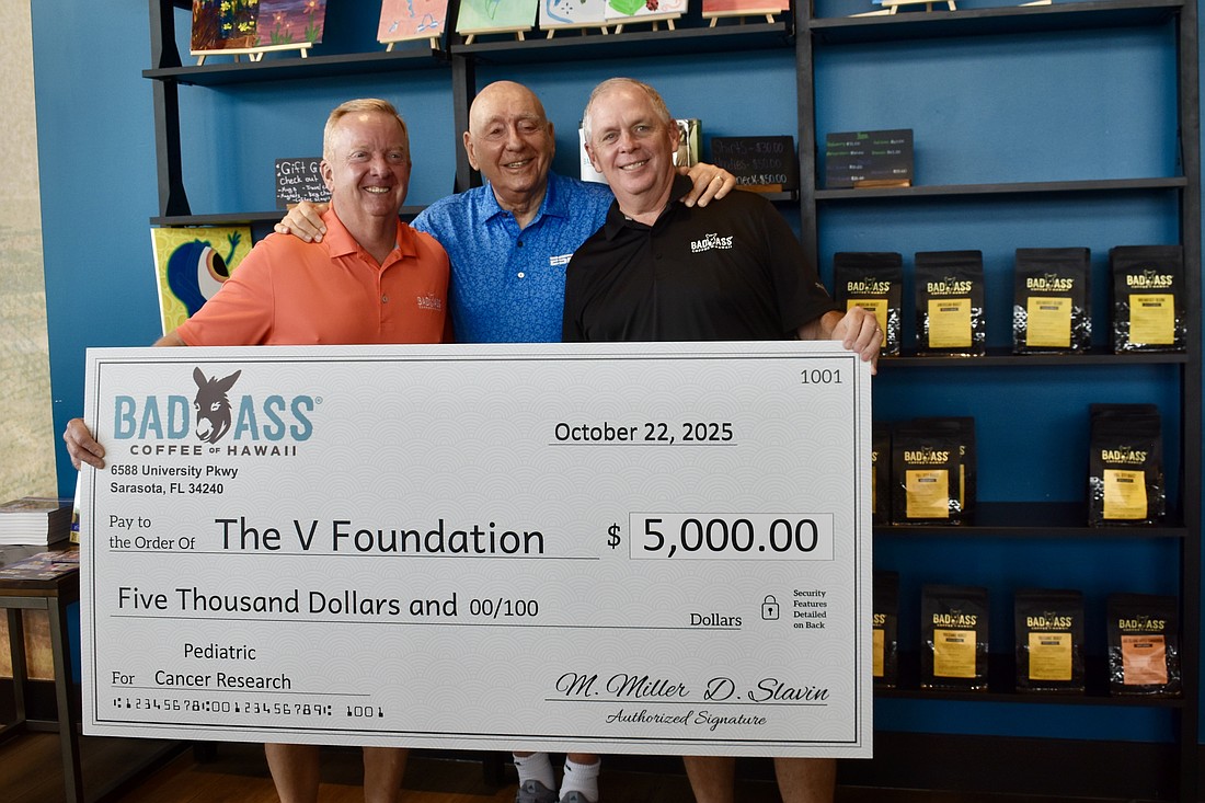 Danny Slavin and Michael Miller, owners of Bad Ass Coffee of Hawaii on University Parkway, donate $5,000 to the Dick Vitale Pediatric Cancer Fund Oct. 10.