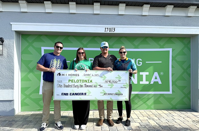 Greg Crawford, area president of M/I Homes, Erika Walker, Pelotonia's philanthropy and stewardship manager and Chase Knopt and Ashtyn Crockett, construction managers at M/I homes pose with the $141,000 check at the Sweetwater benefit home.