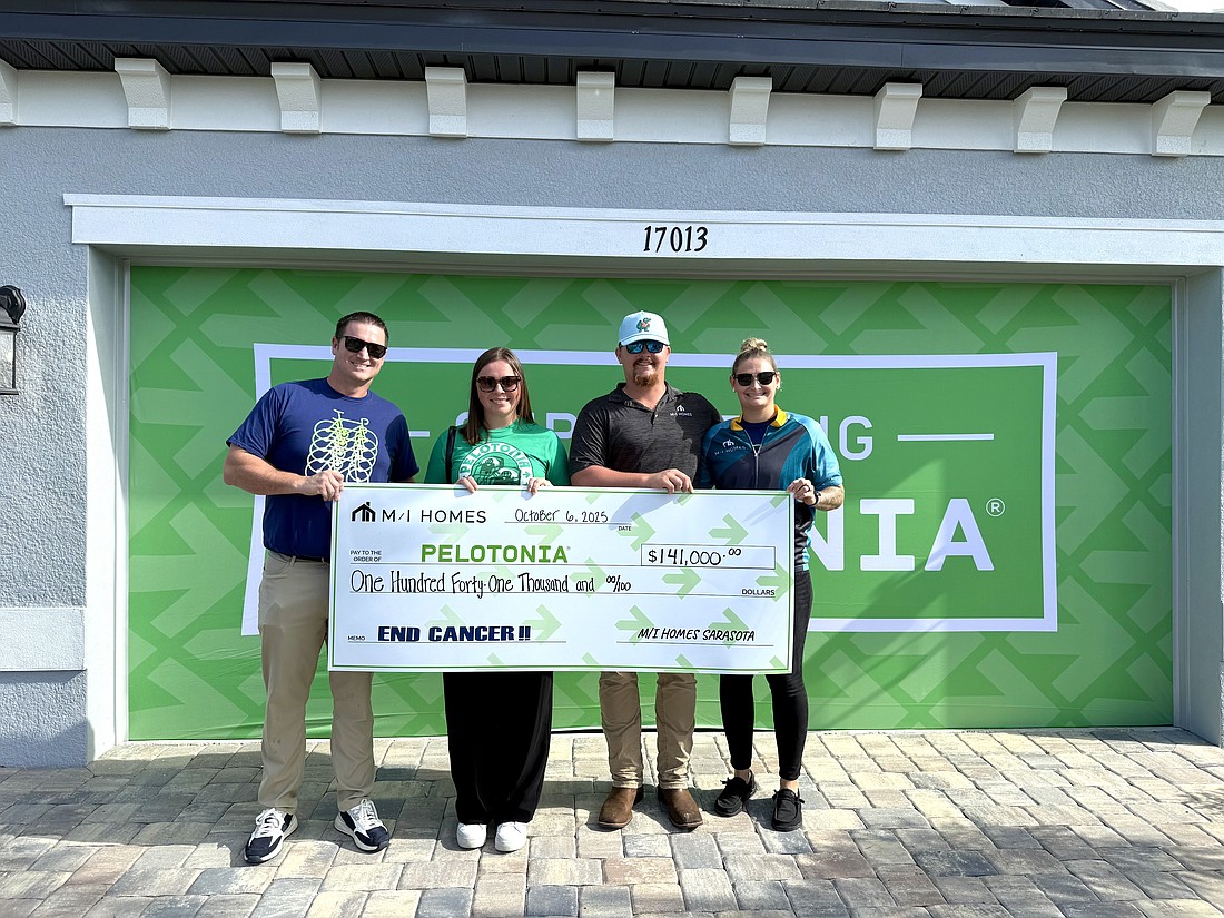 Greg Crawford, area president of M/I Homes, Erika Walker, Pelotonia's philanthropy and stewardship manager and Chase Knopt and Ashtyn Crockett, construction managers at M/I homes pose with the $141,000 check at the Sweetwater benefit home.
