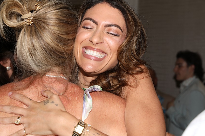 The Sisterhood Project Melissa Mangiapanella gets a quick hug from a guest.