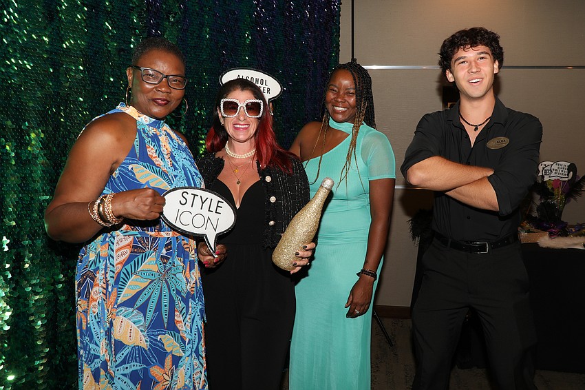 Alex Ivanov assists Dee Dawkins, Rebecca Stern and Tatra Carmichael with the New Orleans themed photo booth.