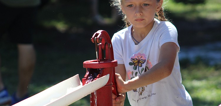 Lakewood Ranch's Jenna Ziegler works quickly to move as much water as she can with a hand pump at the Dakin Harvest Festival Oct. 12 in Myakka.