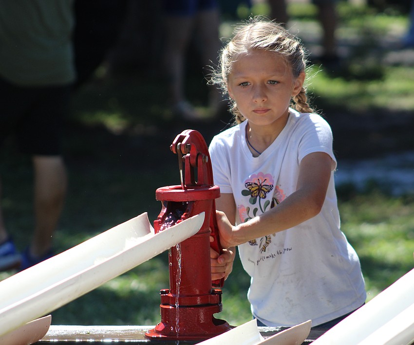 Lakewood Ranch's Jenna Ziegler works quickly to move as much water as she can with a hand pump at the Dakin Harvest Festival Oct. 12 in Myakka.