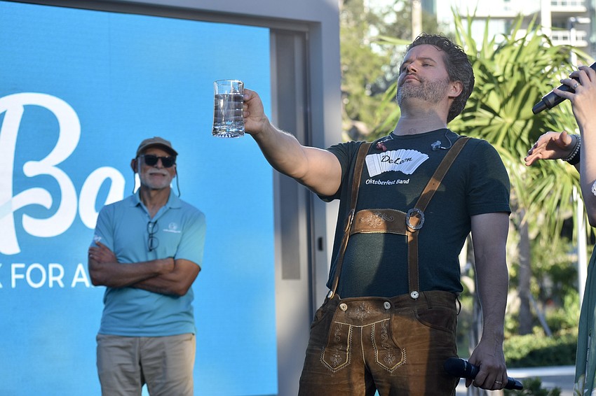Oscar Rodriguez watches as Lance Cox of the DeLeon Oktoberfest Band demonstrates Steinholding.