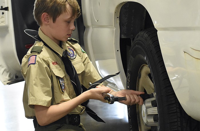 Matthew Hardee, 11, changes a tire.
