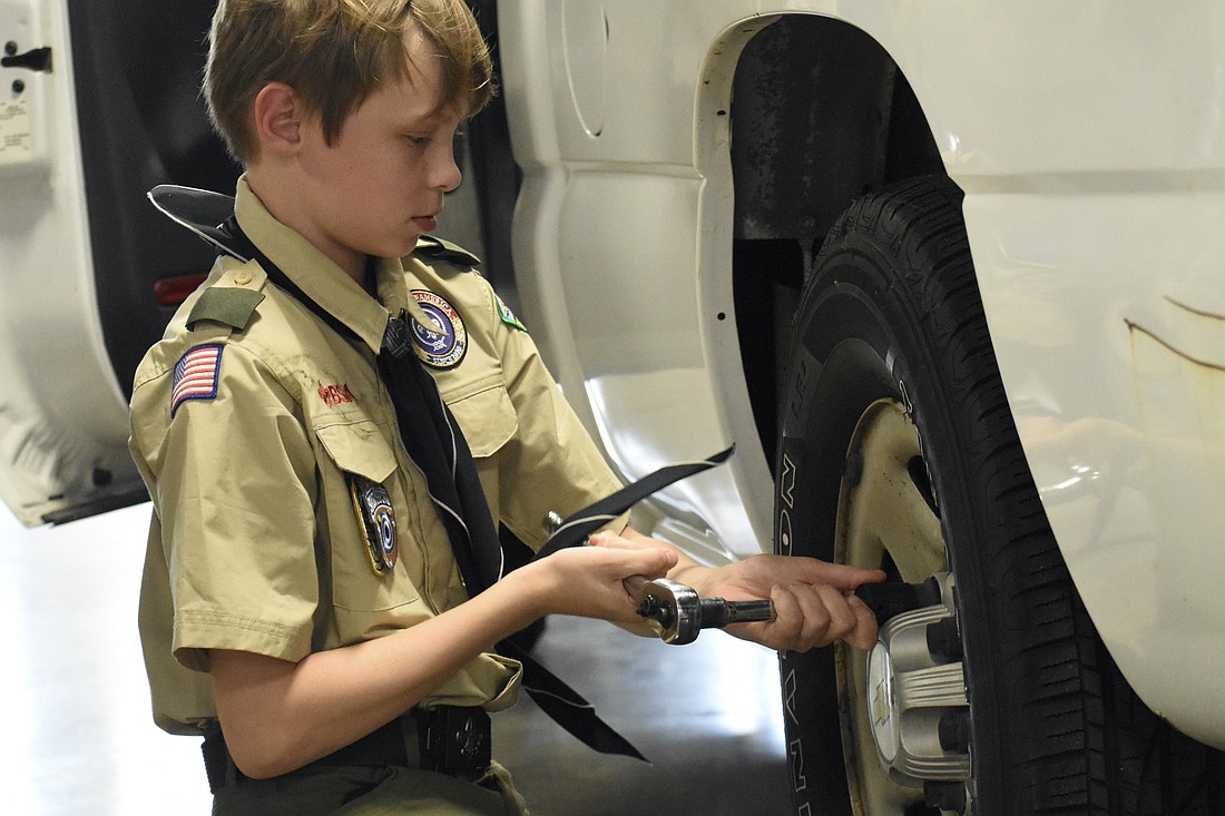 Matthew Hardee, 11, changes a tire.
