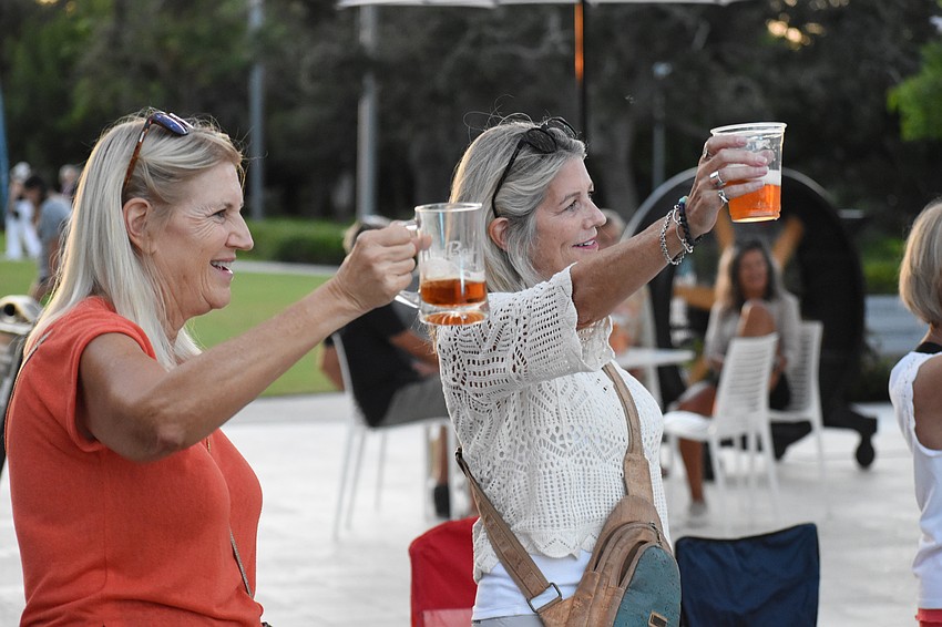 Marti Eidam and Susan Widen join in one last salute as the event ends.