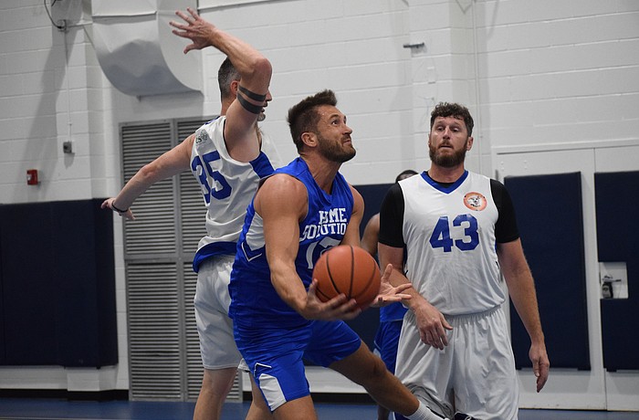 Wes Wilcox (center) goes under the rim searching for a tough bucket during a game between his team, Kari's Face Painting, and Bretz Chiro on Oct. 6 at Longwood Park gym.