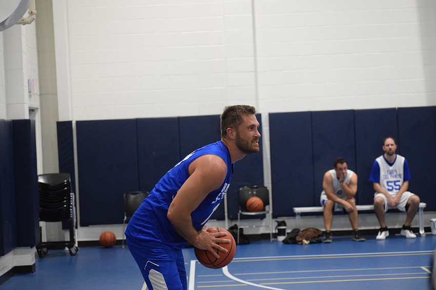 Wilcox stands beyond the 3-point line with the ball, looking for an open teammate to connect with.