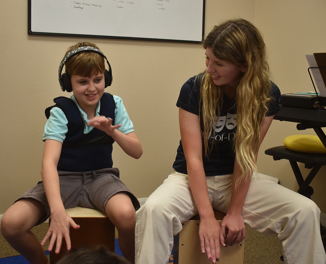 Lakewood Ranch's Everett Wyckoff, a 12-year-old with autism, plays the cajon alongside volunteer Jules Whittemore at Gulf Coast Music Therapy.