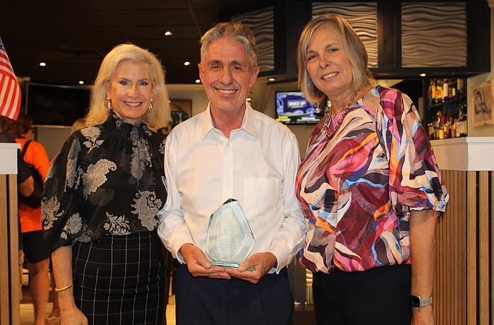 New Kiwanis Club of Longboat Key president Danielle Gladding presents former president Michael Garey, accompanied by his wife, Catherine, with an award for his years of service to the community.
