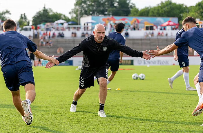 Mika Elovaara (center) high-fives two of his players during prematch warmups with the Richmond Kickers. The Oulu, Finland native and UNC Wilmington alumnus will guide the Paradise into USL League One in 2026.
