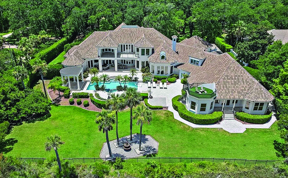 Marshfront home features six bedrooms, seven full and two half-bathrooms, guest suite, wine cellar, office, gym, porches, balconies, outdoor kitchen, elevator, six-car garage and boat slip.