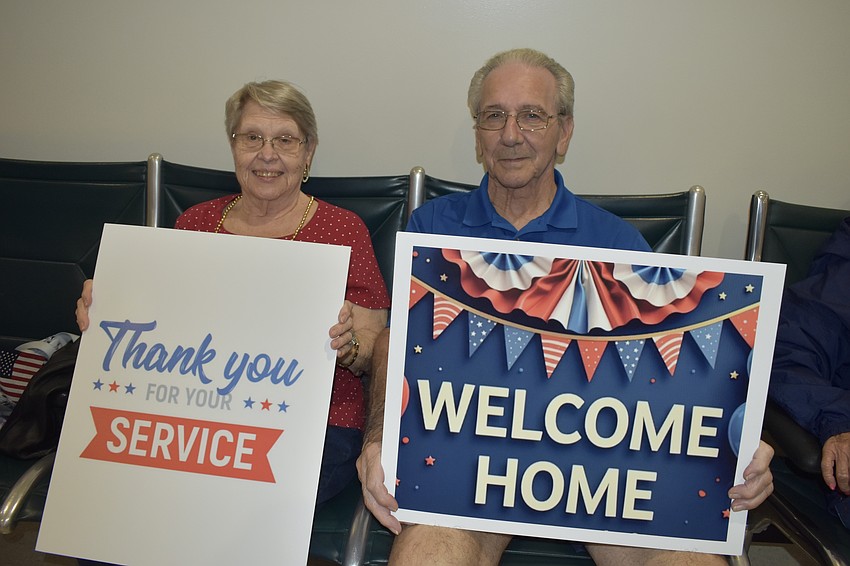 Sarasota's Ann and Jerry Blackburn held signs as the flight arrived.