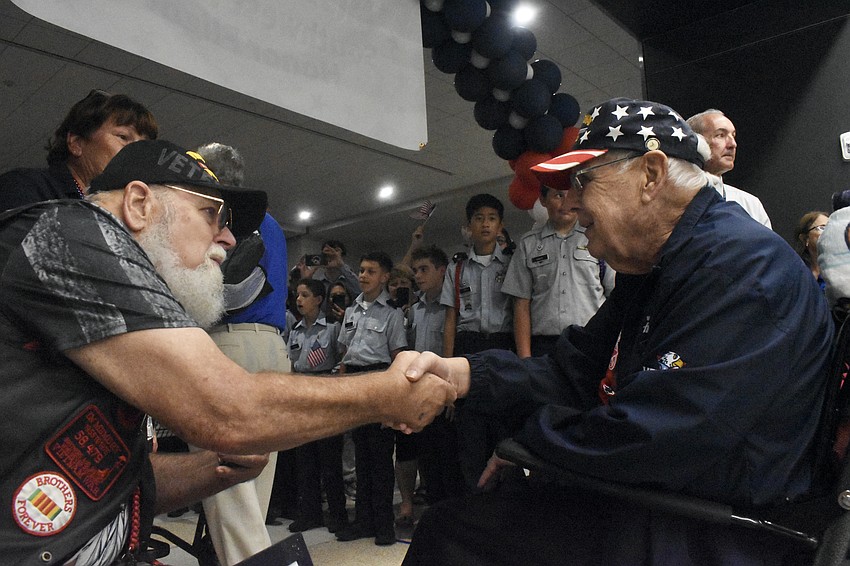 Jim Currie of the Vietnam Brotherhood greets Navy Veteran Thomas Redmond of Sarasota.