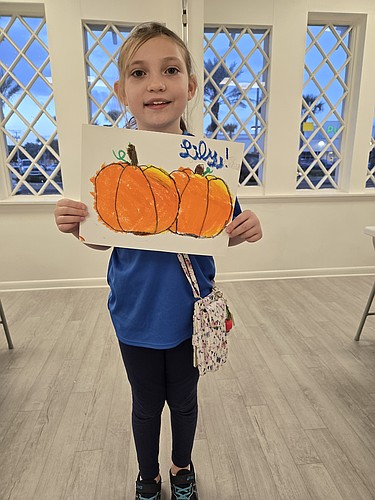 Lily Scheerer shows off her artwork, completed during OMAM's Free Family Art Night on Oct. 3. Courtesy photo
